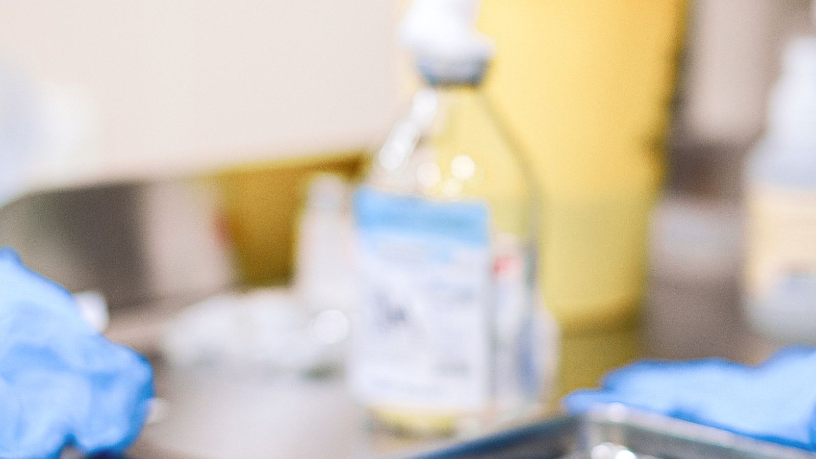 A close-up of a medical syringe resting on a sterile tray in a clinical setting.